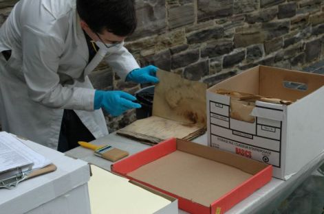 archivist cleaning mouldy document